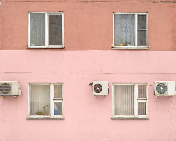 old city house painted pink - windows and conditioners stock photo