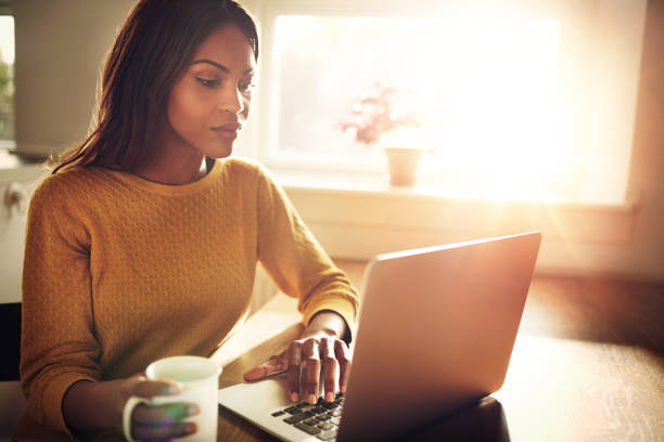 istock Woman checking her computer and holding coffee cup 513117356