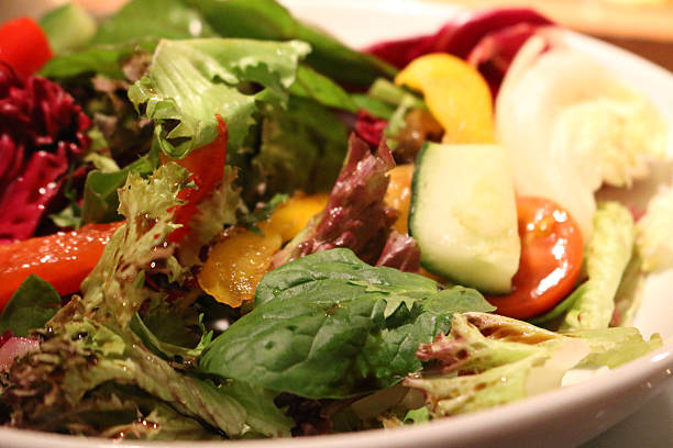 istock Stock close- up image of olive-oil dressed, mixed leaf salad 513117614