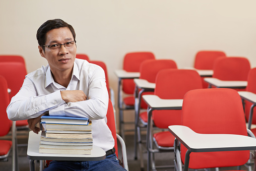 Vietnamese adult student sitting in empty lecture hall