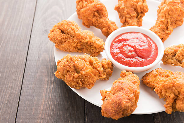 istock Fried chicken drumstick and ketchup on wooden background 513120692