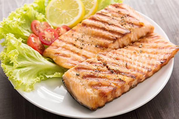 istock Grilled salmon with lemon,tomato on the wooden table 513123008
