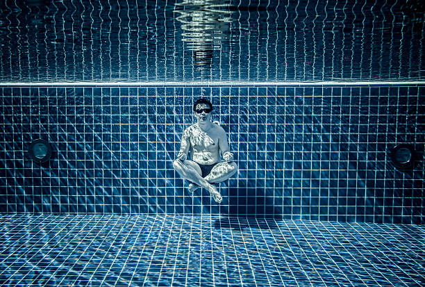 Persons lies under water in a swimming pool