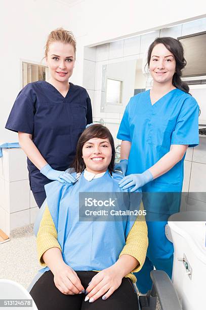 Happy Female Dentist With Assistant And Patient At Dental Office Stock Photo - Download Image Now