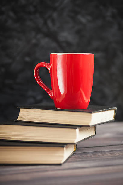istock The red cup and black books on a dark background 513126452