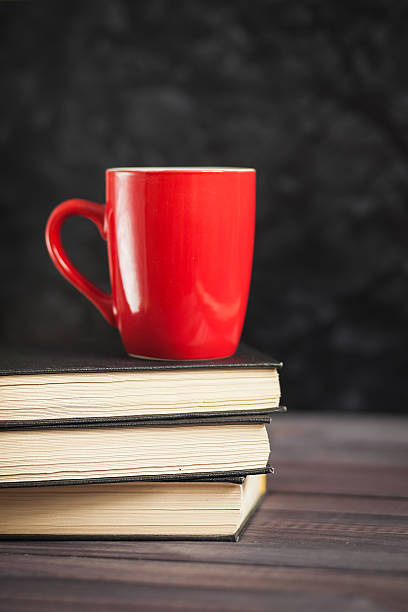 istock The red cup and black books on a dark background 513126748
