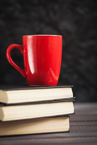 istock The red cup and black books on a dark background 513127600