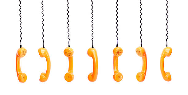 istock Handset piece from an old phone suspended by phone cord 513128992