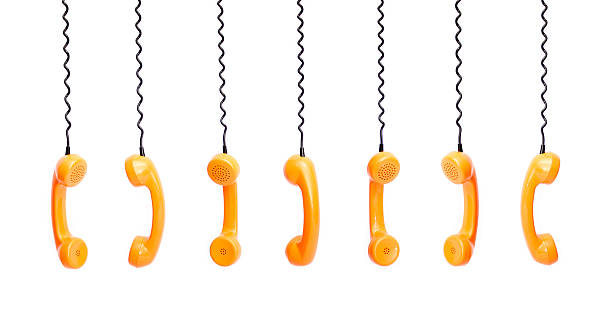 Handset piece from an old phone suspended by phone cord stock photo