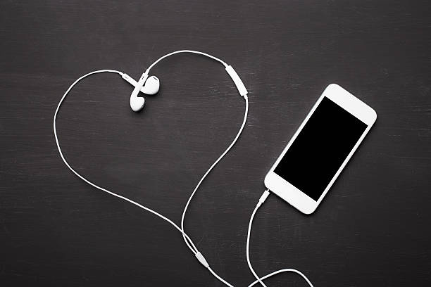 мобильный телефон с наушники музыка слушания - equipment human ear sound music стоковые фото и изображения