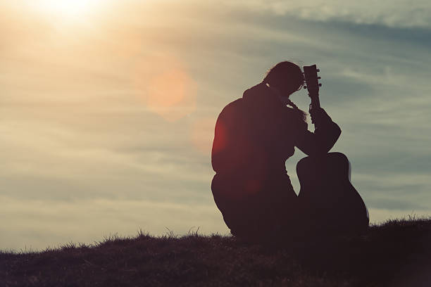 istock Girl with guitar in the grass 513131048