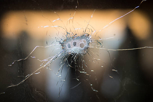 Bullet holes in a front windshield stock photo