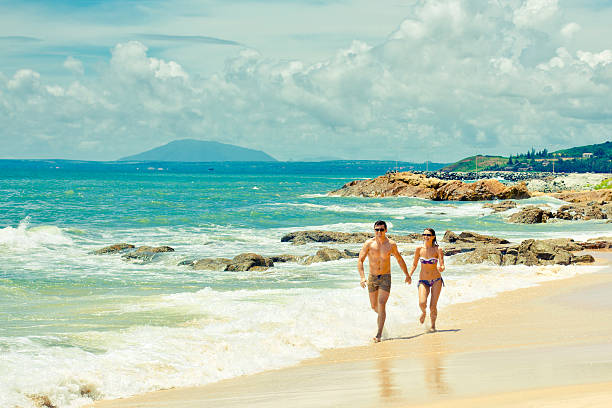 istock Couple running on a sandy beach 513133451