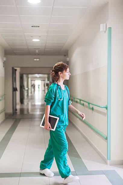 enfermera caminando en un hospital corredor - patient room fotografías e imágenes de stock