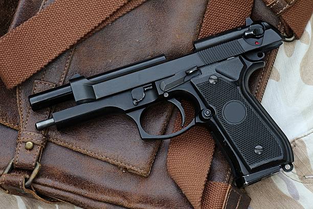 istock handgun lying over a Leather handbag, 513136327