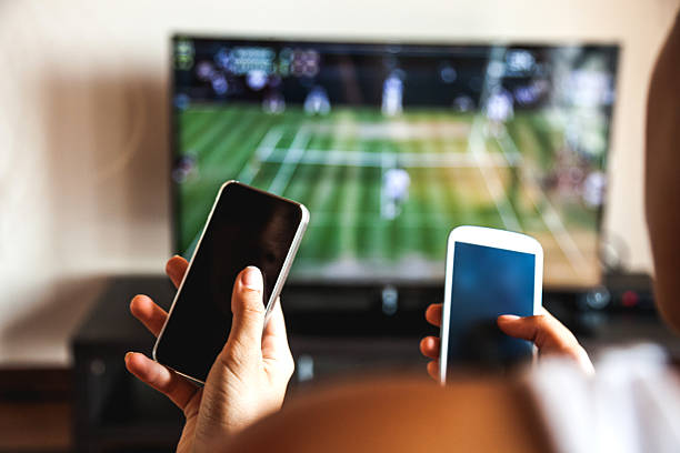 amigos mediante teléfono móvil durante un campeonato de tenis - watching tv fotografías e imágenes de stock