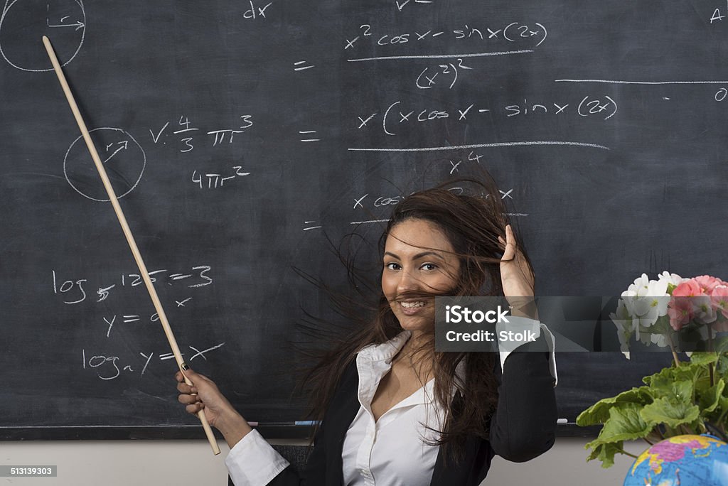 Battling her hair A Middle Eastern female teacher in front of the classroom Adult Stock Photo