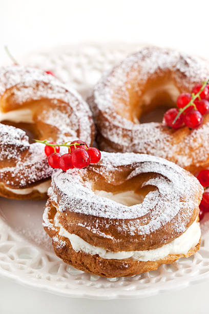 istock Cream puff rings decorated with fresh red currant 513161743