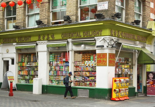 London, England - Sept 4th, 2014: A man walks by the Oriental Delight supermarket in Macclesfield Street in London's Chinatown District - a community of restaurants and businesses since the 1950s