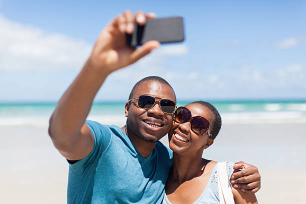 istock African couple taking a selfie together on the beach 513165459
