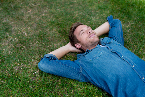 Happy man relaxing at the park lying down