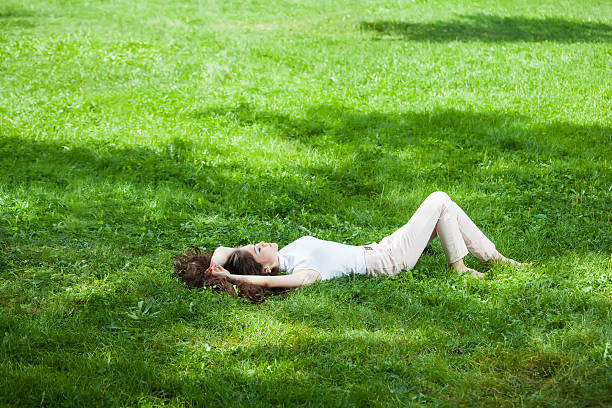 istock young woman laying on grass 513177971