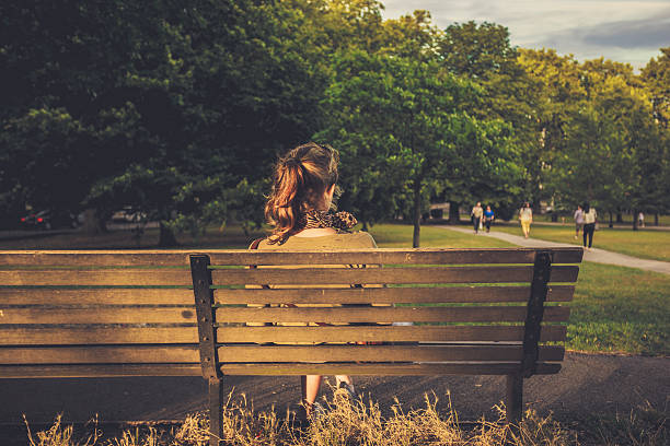 istock Young woman sitting on a bench at sunset 513179815
