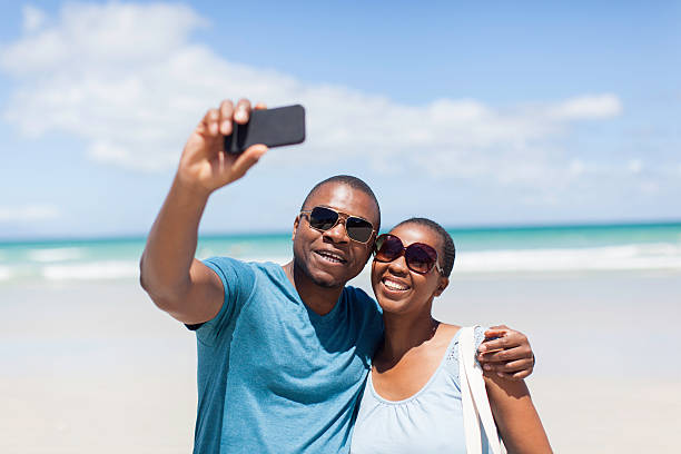 istock African couple taking a selfie together on the beach 513181563