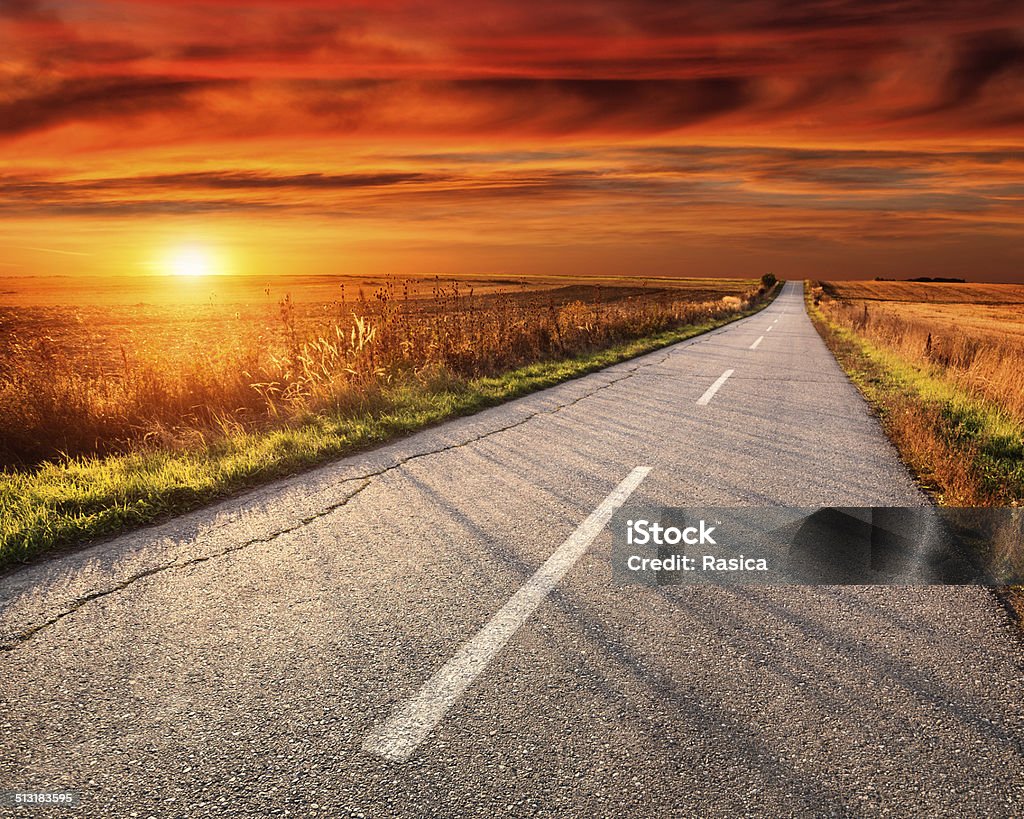 Driving on an empty road at sunset Driving on an empty asphalt road at sunset Agricultural Field Stock Photo