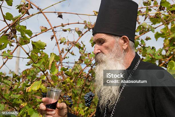 Sacerdote Ortodox Senior De Degustación De Vino Tinto Cosechar Europa Foto de stock y más banco de imágenes de 65-69 años