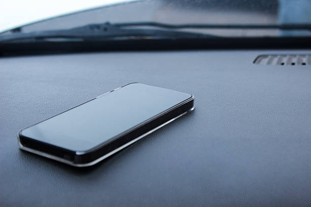 istock Mobile phone on car cockipt man in background 513209635