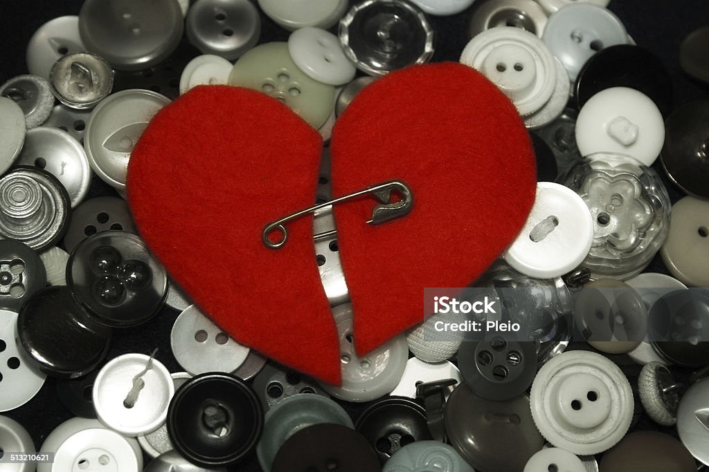 pinned together broken heart pinned together. On top of buttons. Art And Craft Stock Photo