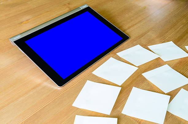 luogo di lavoro con tablet pc (il riquadro blu) e foglietti adesivi - newspaper digital tablet digitally generated image note pad foto e immagini stock