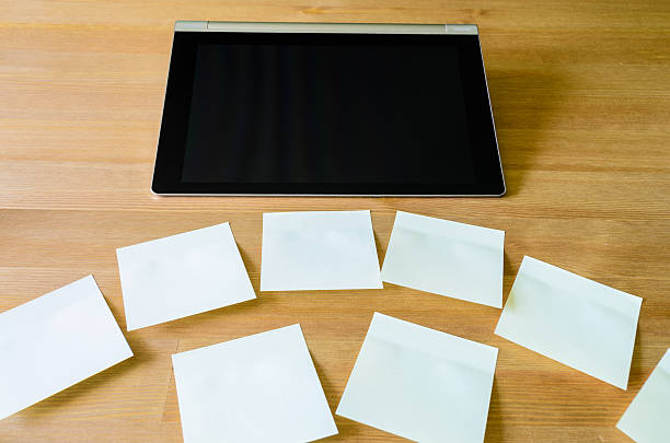luogo di lavoro con tablet pc e diversi foglietti adesivi - newspaper digital tablet digitally generated image note pad foto e immagini stock