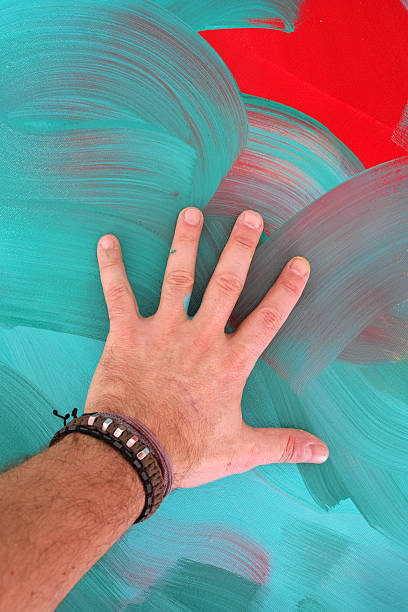 istock Man's Hand On The Colourful Painted Background 513223326