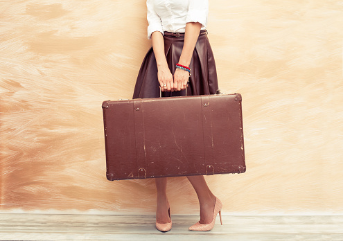 Woman holding antique suitcase for traveling