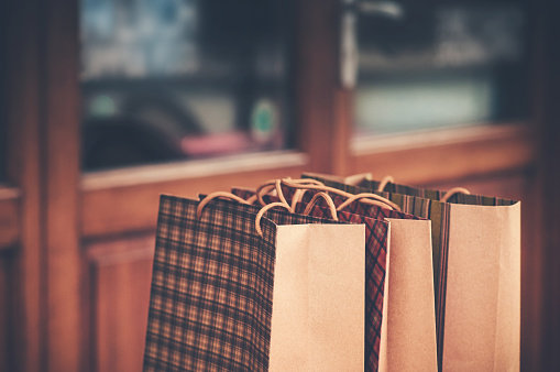 Shopping bags in foreground, defocused shop window on background. Consumerism concept.