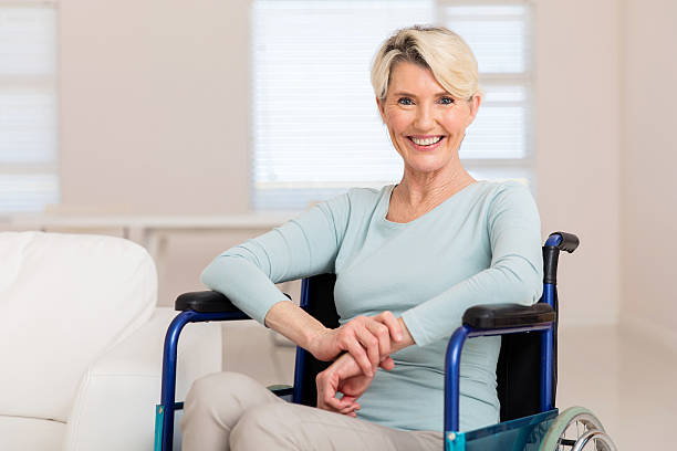 istock mid age woman sitting on wheelchair 513224278