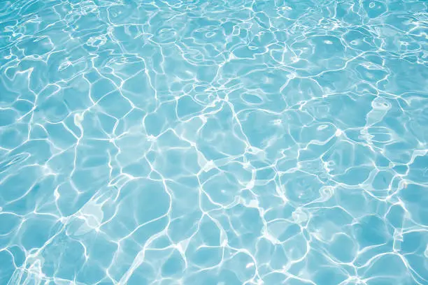 Beautiful water surface in swimming pool with sun reflection