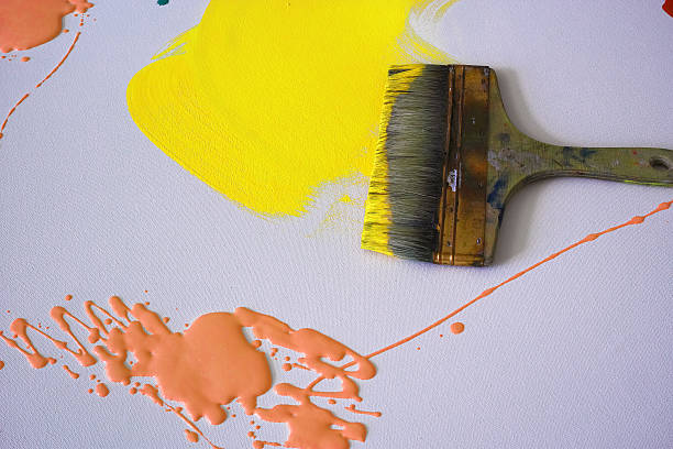 Wide Paintbrush Yellow And Orange Paints On The Canvas stock photo