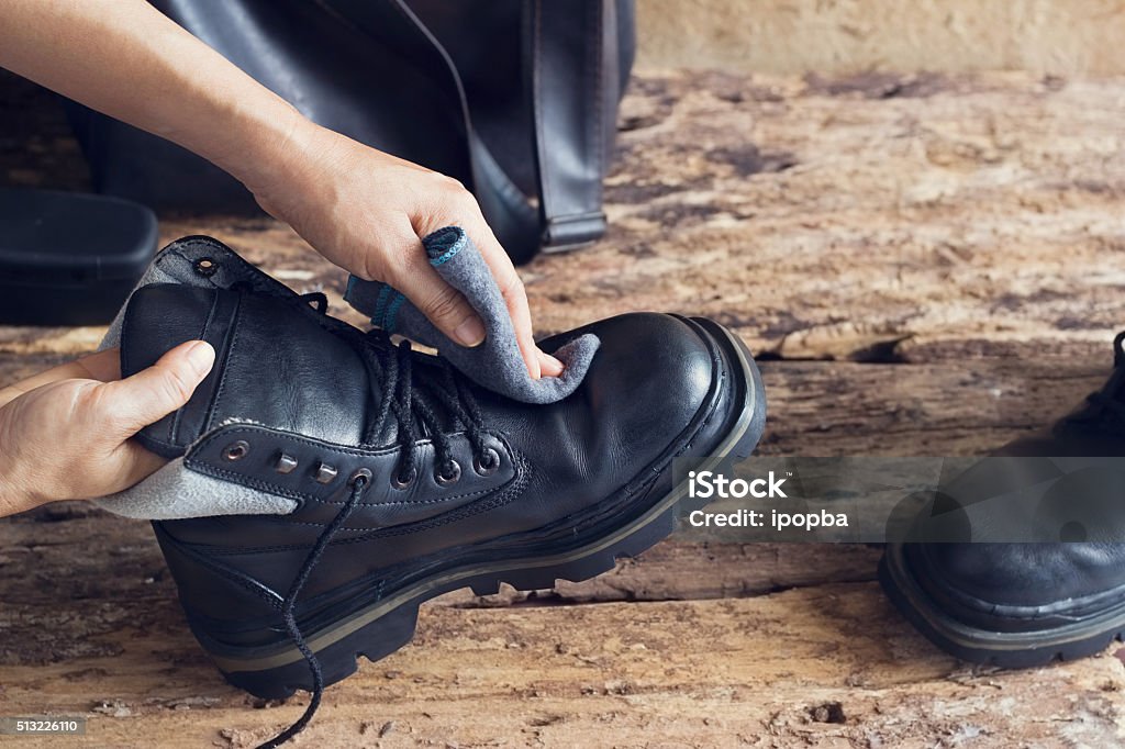 Cleaning shoes on wooden background Boot Stock Photo