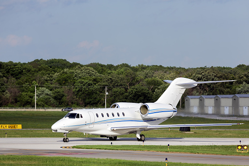 A business jet at an airport taxiing after landing.  