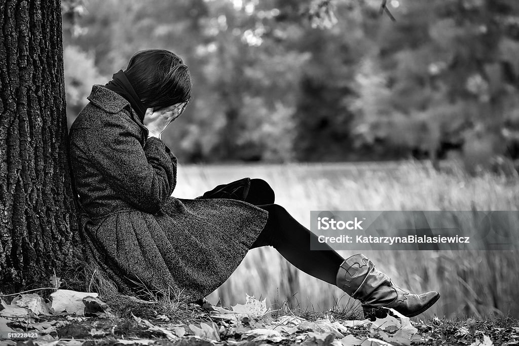 Autumn despair An image of desperate women in autumn park Adult Stock Photo