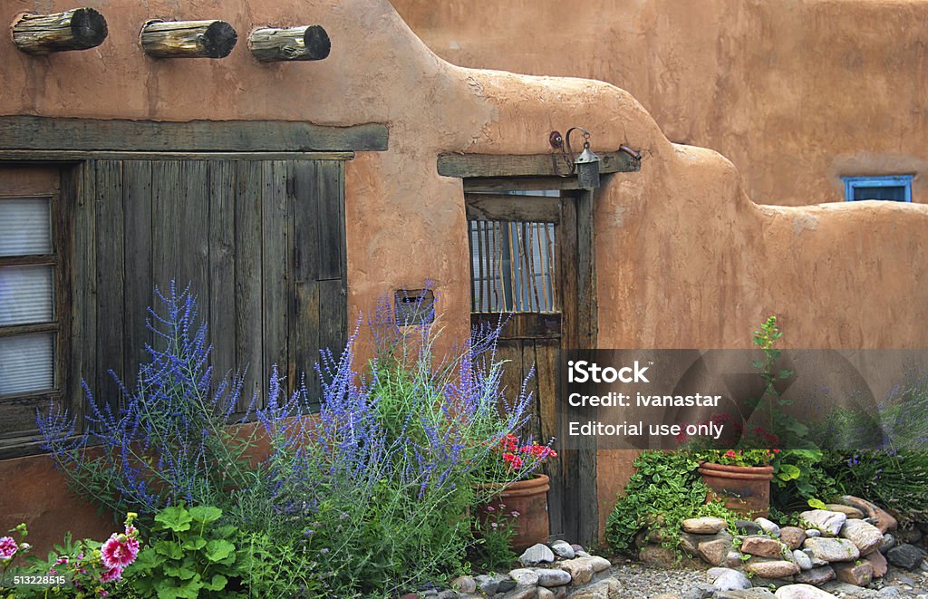 Santa Fe Old Adobe House with Stucco Wall and Flowers Santa Fe, USA - July 20, 2014: Old Santa Fe Adobe house with potted flowers and rock garden, on Canyon Road. New Mexico Stock Photo