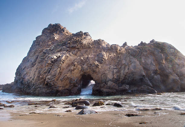 istock Waves break thru the hole in Keystone/Keyhole Pfeiffer Beach Arch 513229021