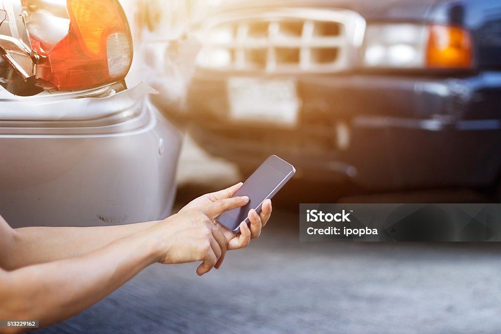 Hombre usando teléfono inteligente en la carretera después del accidente de tráfico - Foto de stock de Accidente de automóvil libre de derechos