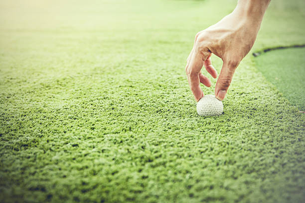 istock Golfer putting a golf ball onto green grass field 513229952