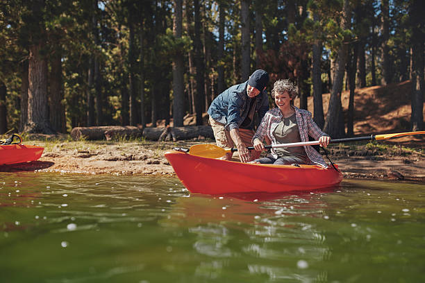 apprendimento di fila in kayak - canoeing canoe senior adult couple foto e immagini stock