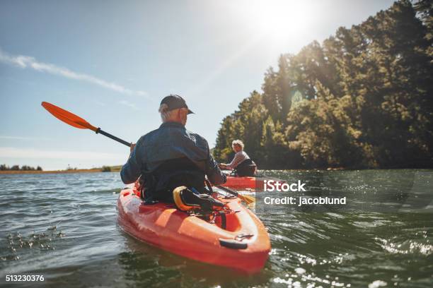 Couple Kayaking In The Lake On A Sunny Day Stock Photo - Download Image Now - Kayaking, Senior Couple, Senior Adult