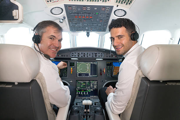 los pilotos de avión en la cabina luciendo felices - pilot cockpit flying business fotografías e imágenes de stock